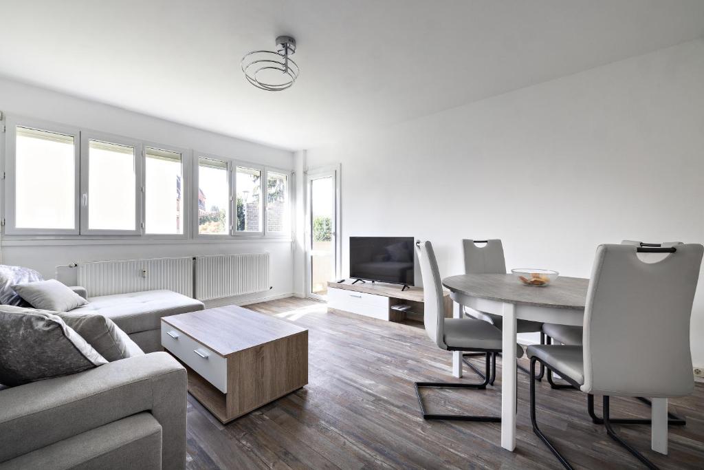 een woonkamer met een tafel en een bank bij le zentop in Chalon-sur-Saône