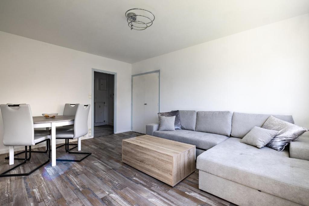 un salon avec un canapé et une table dans l'établissement le zentop, à Chalon-sur-Saône