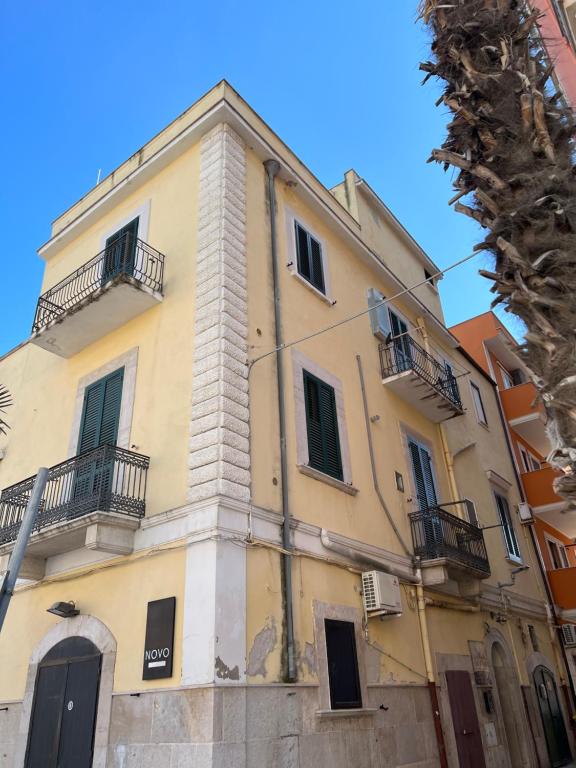 a yellow building with balconies on the side of it at B&B Del Corso in Margherita di Savoia