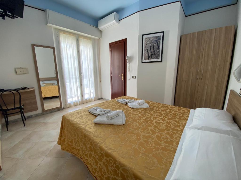 um quarto de hotel com uma cama com duas toalhas em Hotel Nanni Garnì em Rimini