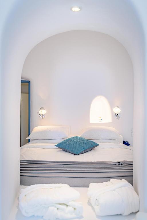 a bedroom with a bed with two towels on it at Aristos Life Luxury Cave Villas in Oia