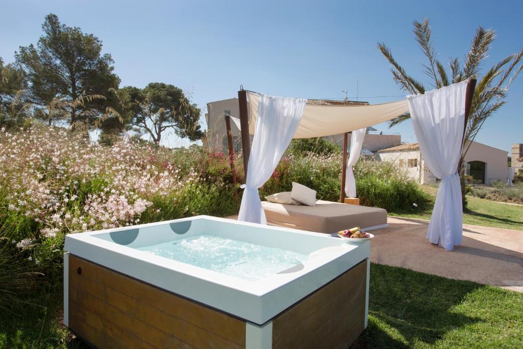 a hot tub in a yard with a tent at Fontsanta Hotel Thermal & Spa - Adults Only in Colònia de Sant Jordi