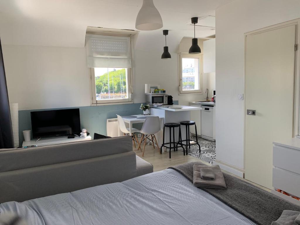 ドゥアルヌネにあるAppartement Design V Port de Tréboul-Douarnenezのベッドルーム1室(ベッド1台付)、キッチン(テーブル付)