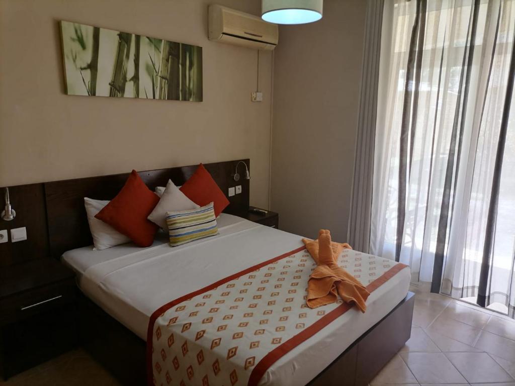 um quarto com uma cama com um urso de peluche sentado sobre ele em Le Choisy Mauritius em Mont Choisy