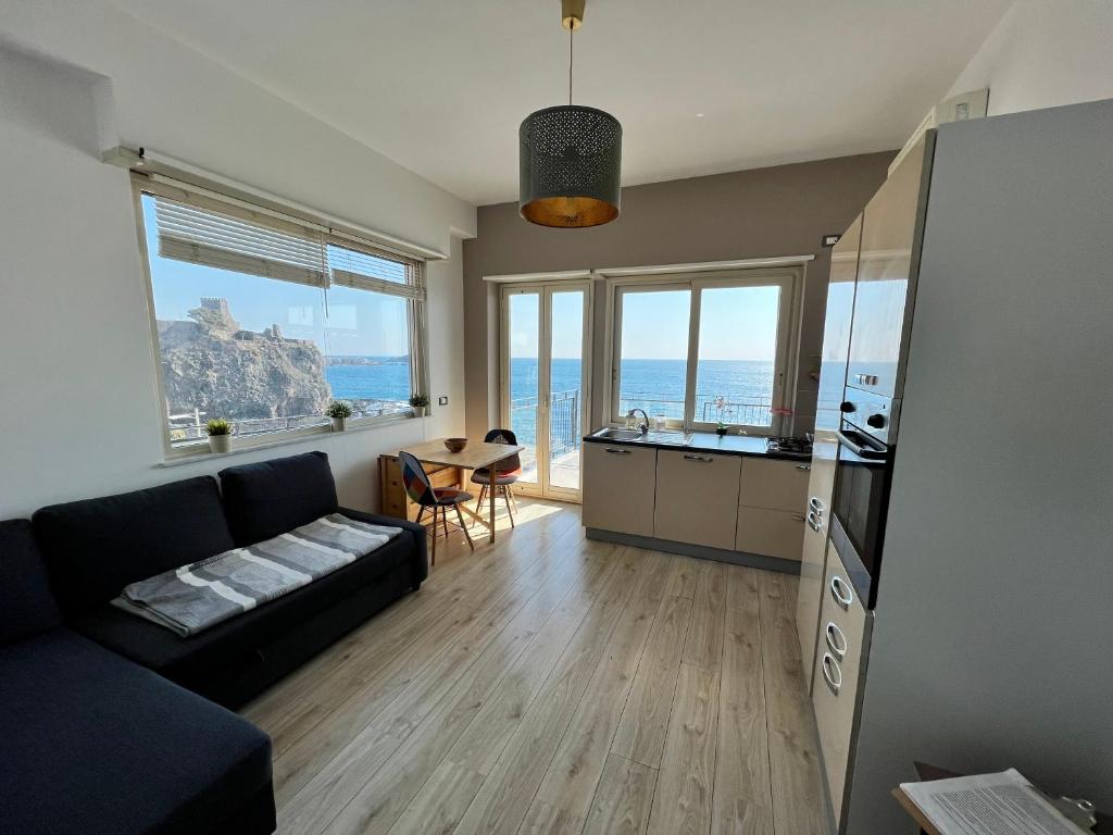 een woonkamer met een bank en een keuken bij Casa Vitale in Aci Castello