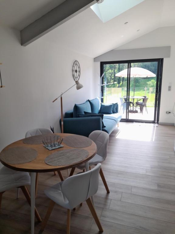 ein Wohnzimmer mit Tisch und Couch in der Unterkunft Gîte des Allas in Campagne