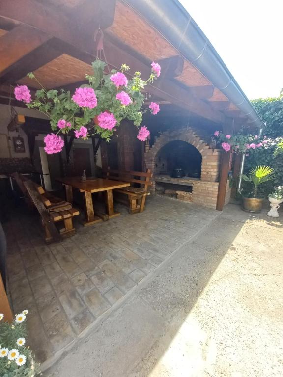 un patio con mesa de madera y chimenea en Dvorska oaza en Sremski Karlovci