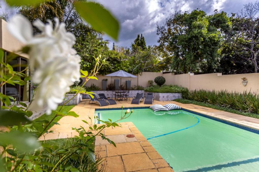 uma piscina no quintal de uma casa em Fleur de Lis Guesthouse em Krugersdorp