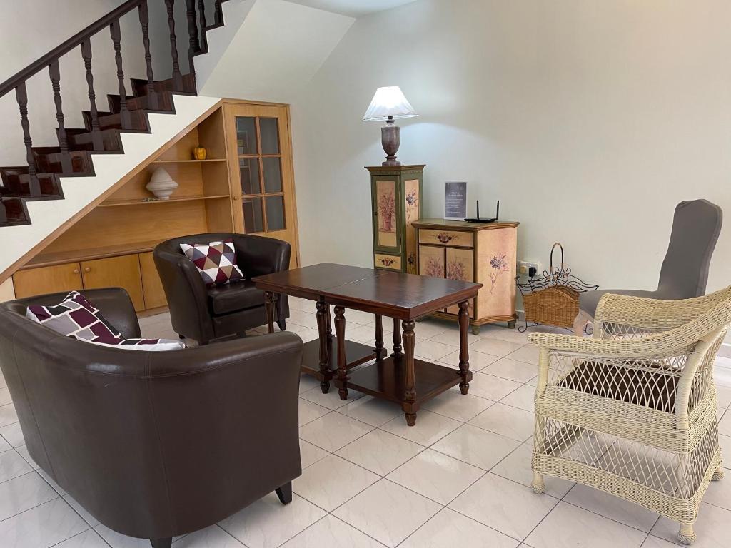 ein Wohnzimmer mit einem Tisch, Stühlen und einer Treppe in der Unterkunft JML Family Homestay ~ Entire Residential Home in Kota Kinabalu