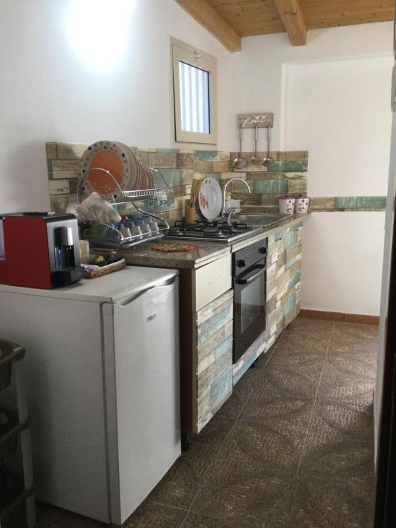a kitchen with a stove top oven next to a counter at Infinity of stars a marzamemi in Marzamemi