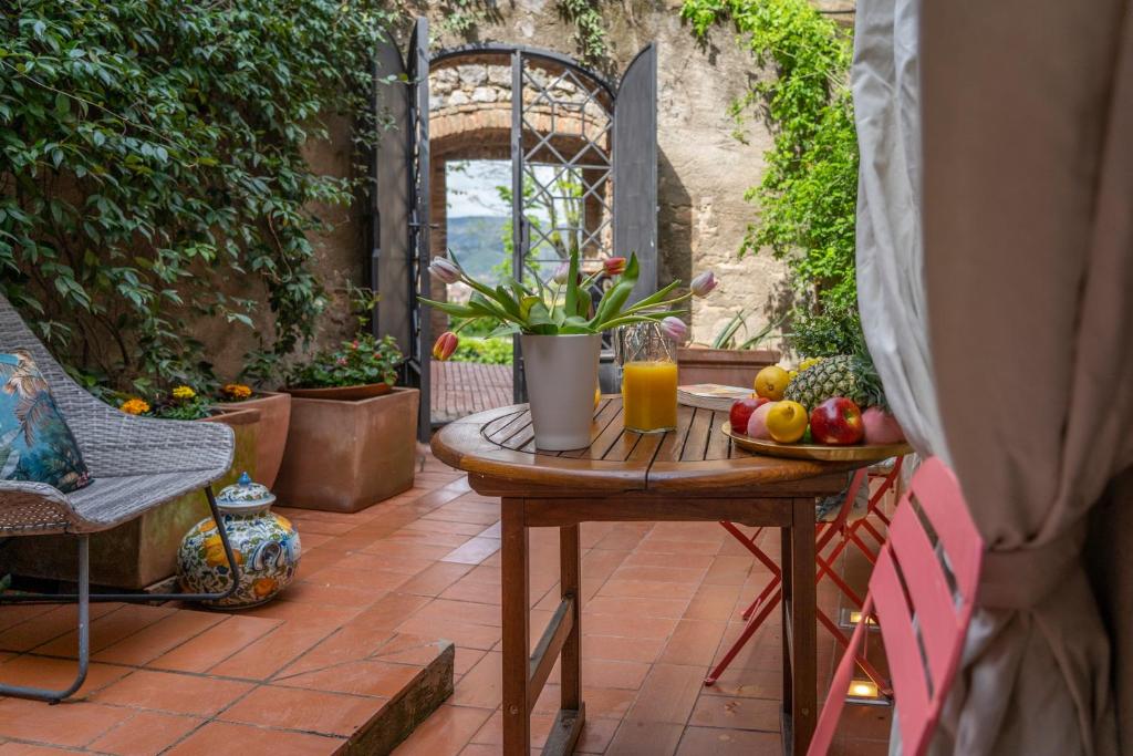 a table with a bowl of fruit and a glass of orange juice at Casa Bardi in San Gimignano