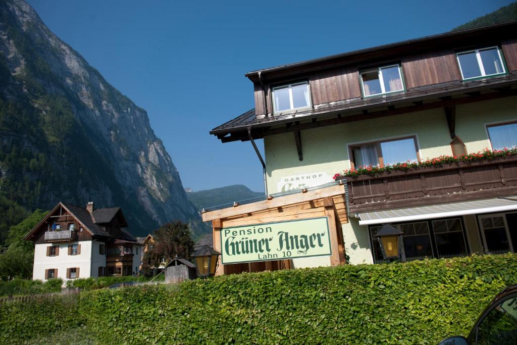 a house with a sign on the side of it at Gasthof Pension Grüner Anger in Hallstatt
