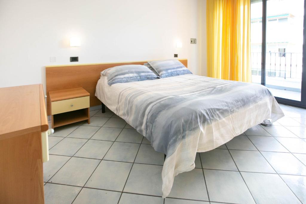 a bedroom with a bed and a large window at Residence Villa Dei Pini in Rimini