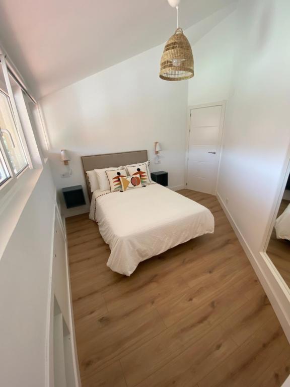 穆羅斯的住宿－Dania Home Esteiro，卧室配有白色的床,铺有木地板