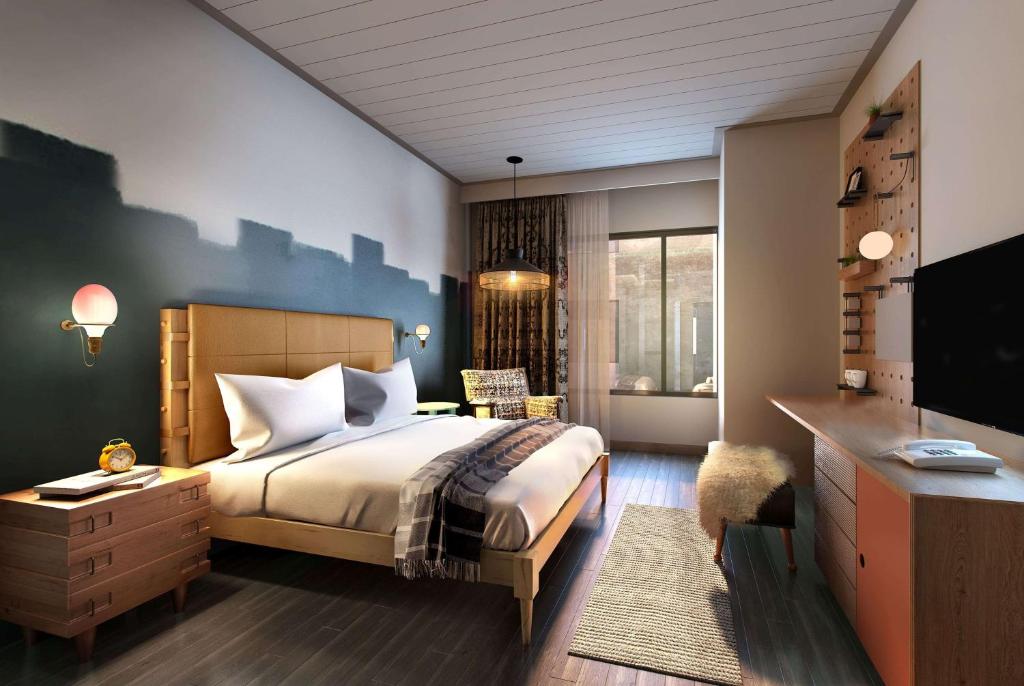a bedroom with a bed and a desk and a television at Origin Austin, a Wyndham Hotel in Austin