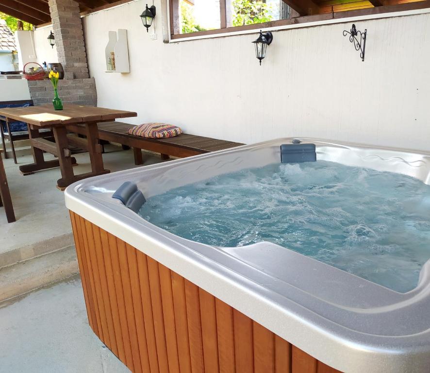 a large hot tub in a patio with a table at Ribizli Vintage Vendégház in Parád