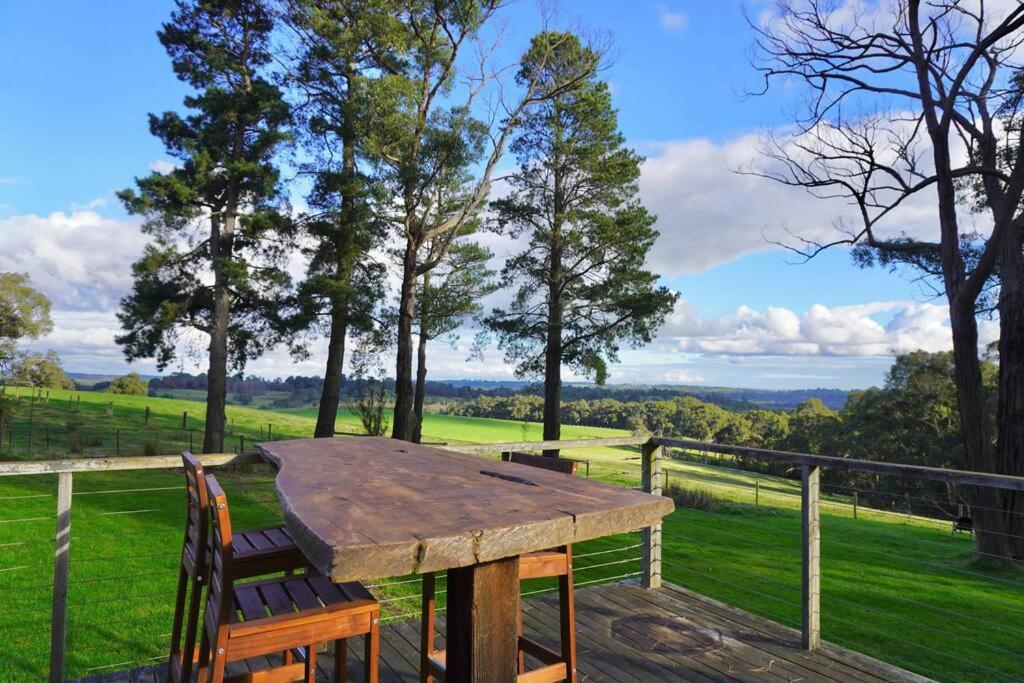 Menzies Creek的住宿－Gorgeous villa 10 acre of land，观景甲板上的木桌和椅子