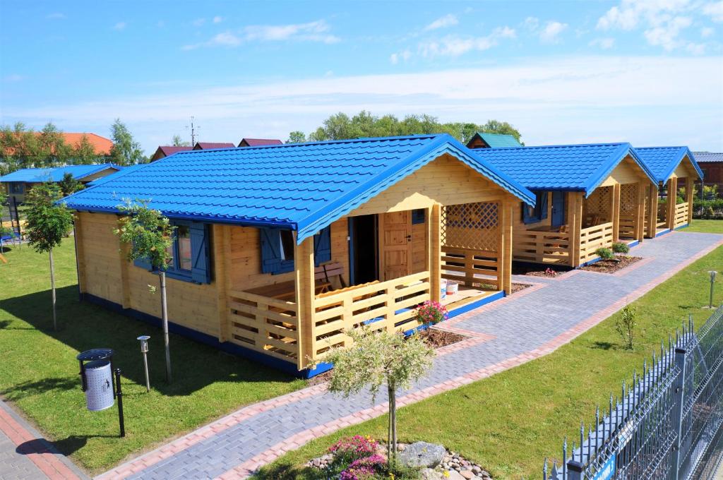 a row of modular homes with blue roofs at WIR Gąski - domki letniskowe in Gąski