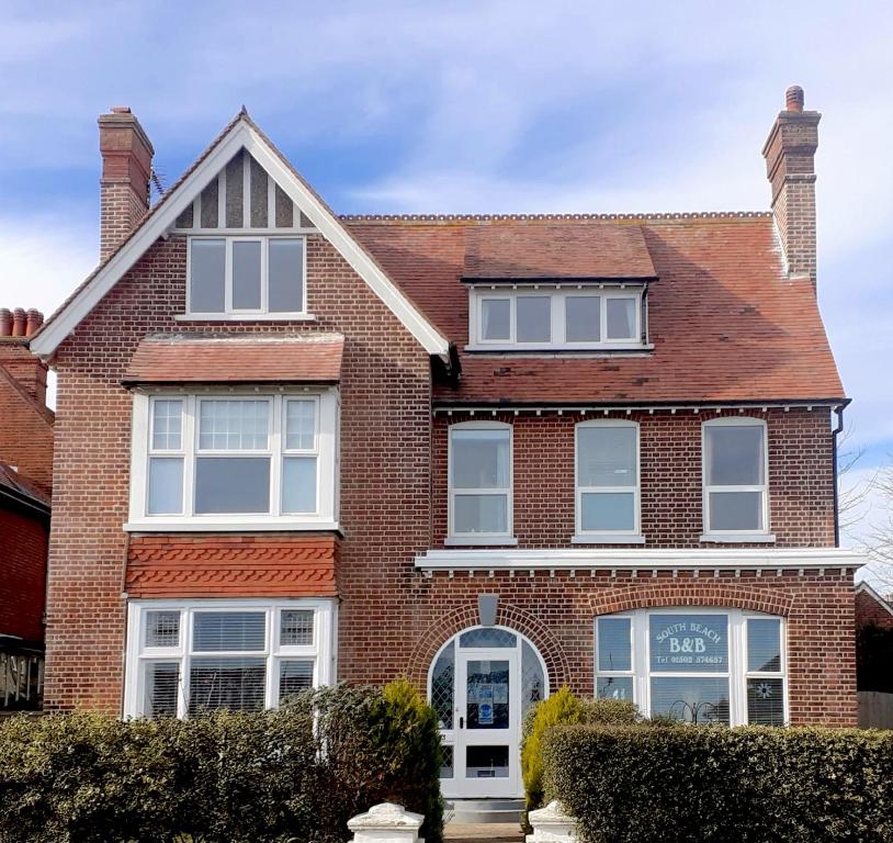 a red brick house with white windows at South Beach B & B in Lowestoft