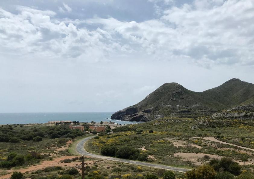 una strada sul fianco di una montagna con l'oceano di Cala Reona Holiday Apartment a Cabo de Palos