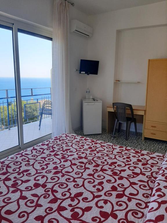 a bedroom with a bed and a view of the ocean at Hotel Conca d'Oro in Stalettì
