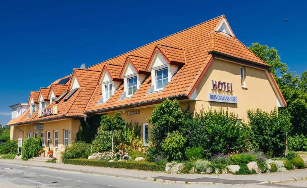 a hotel with an orange roof on a street at Hotel Brinckmansdorf in Rostock