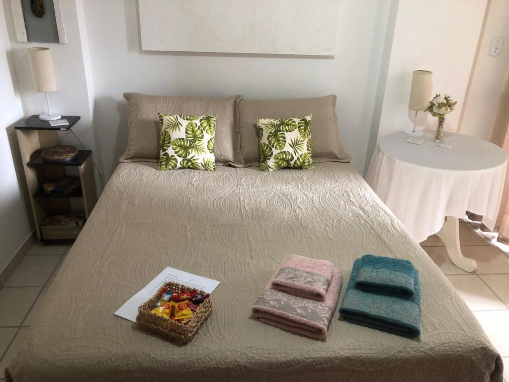 Una cama con dos cestas y toallas. en O PARAÍSO É AQUI! Apto muito próximo a praia en Guarapari