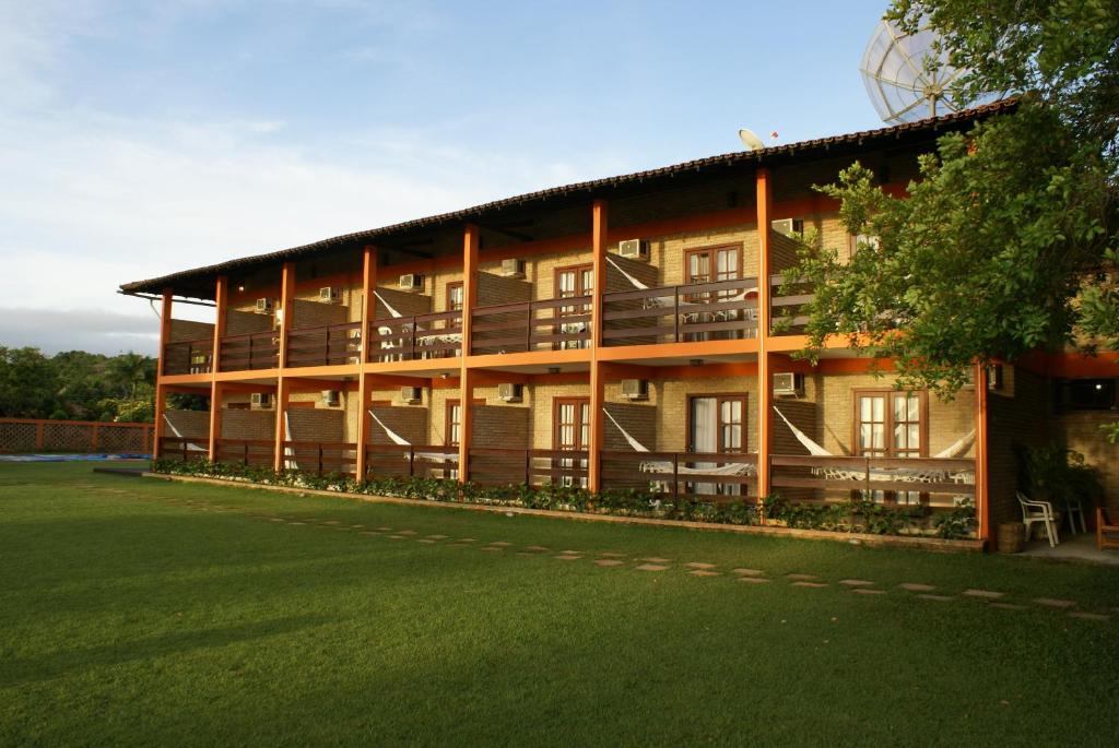 un gran edificio con césped delante en Hotel Cumuruxatiba, en Cumuruxatiba