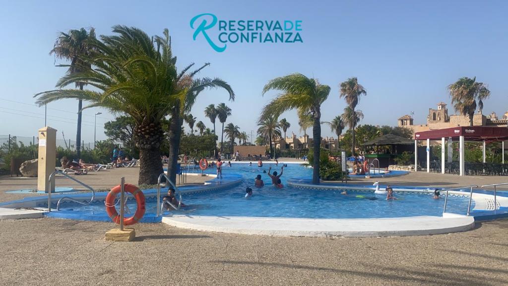 - une piscine dans un complexe avec des personnes dans l'établissement DUPLEX BAHIA SuR RESERVA DE CONFI-ANZA, à San Fernando