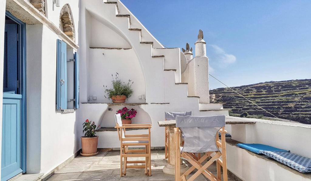 a balcony with a table and chairs and stairs at Tinoshomelidays Residences in Venardatos