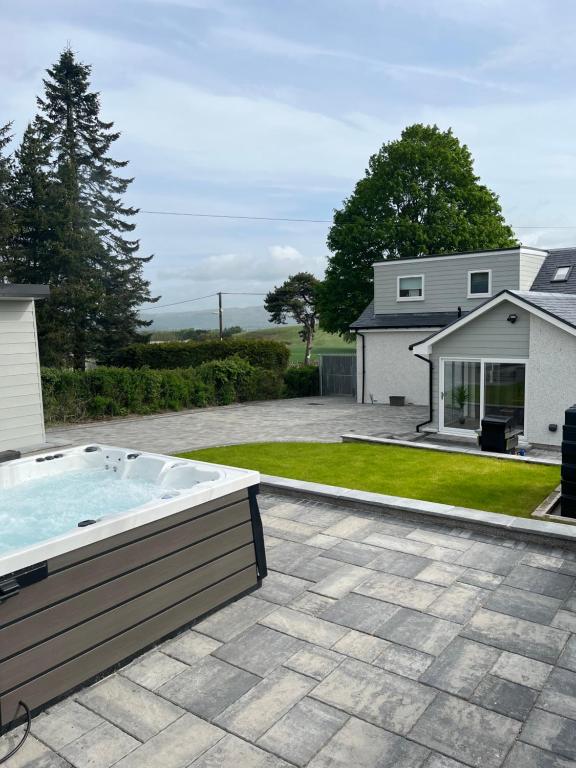 a backyard with a hot tub and a house at 4 Bed cottage with Hot tub in Bannockburn