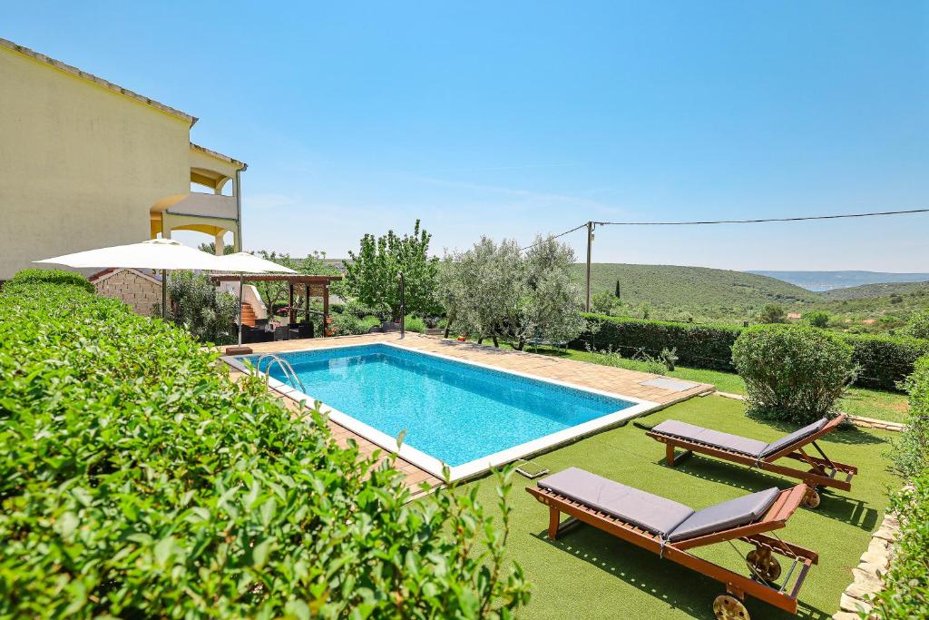een zwembad in een tuin met twee stoelen en een huis bij Gale Vila in Sveti Petar