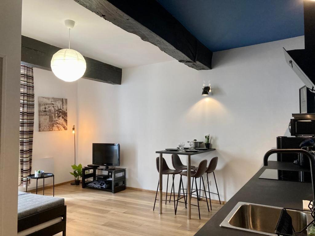 a kitchen and living room with a table and chairs at LES HALLES 2 - Central in Mont-de-Marsan