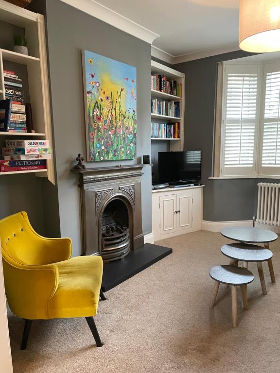a living room with a yellow chair and a fireplace at Period two-bed house, next to river and city in York