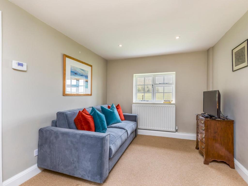 a living room with a blue couch and a tv at Pass the Keys Charming Country Cottage With Spectacular Views in Chichester