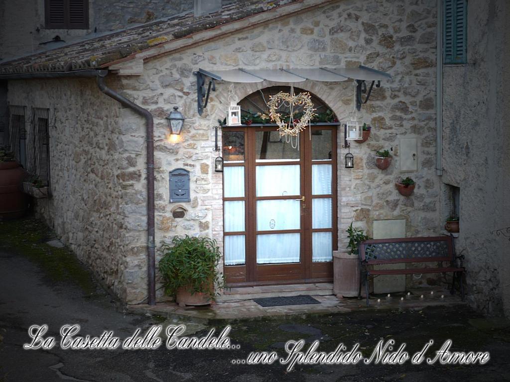 una entrada a un edificio de piedra con puerta de madera en Holiday Home La Casetta delle Candele, en Montemerano