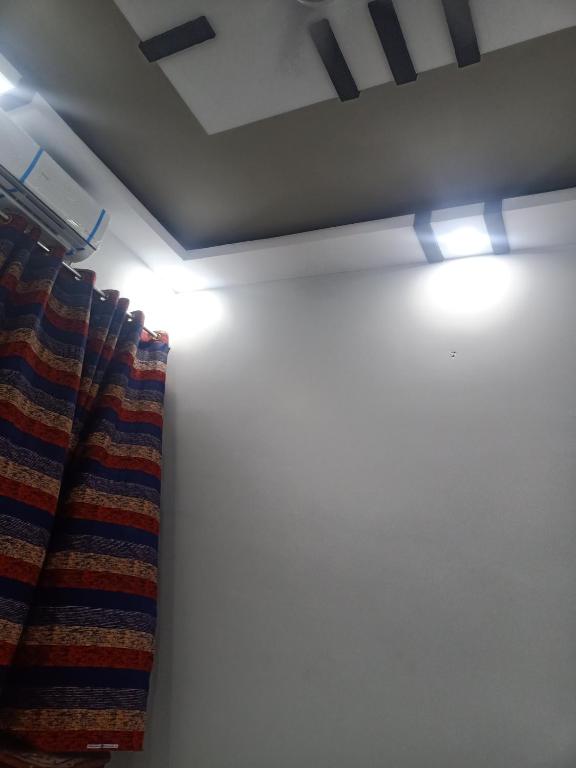 um quarto com uma cortina e luzes no tecto em Executive Inn Guest House em Karachi