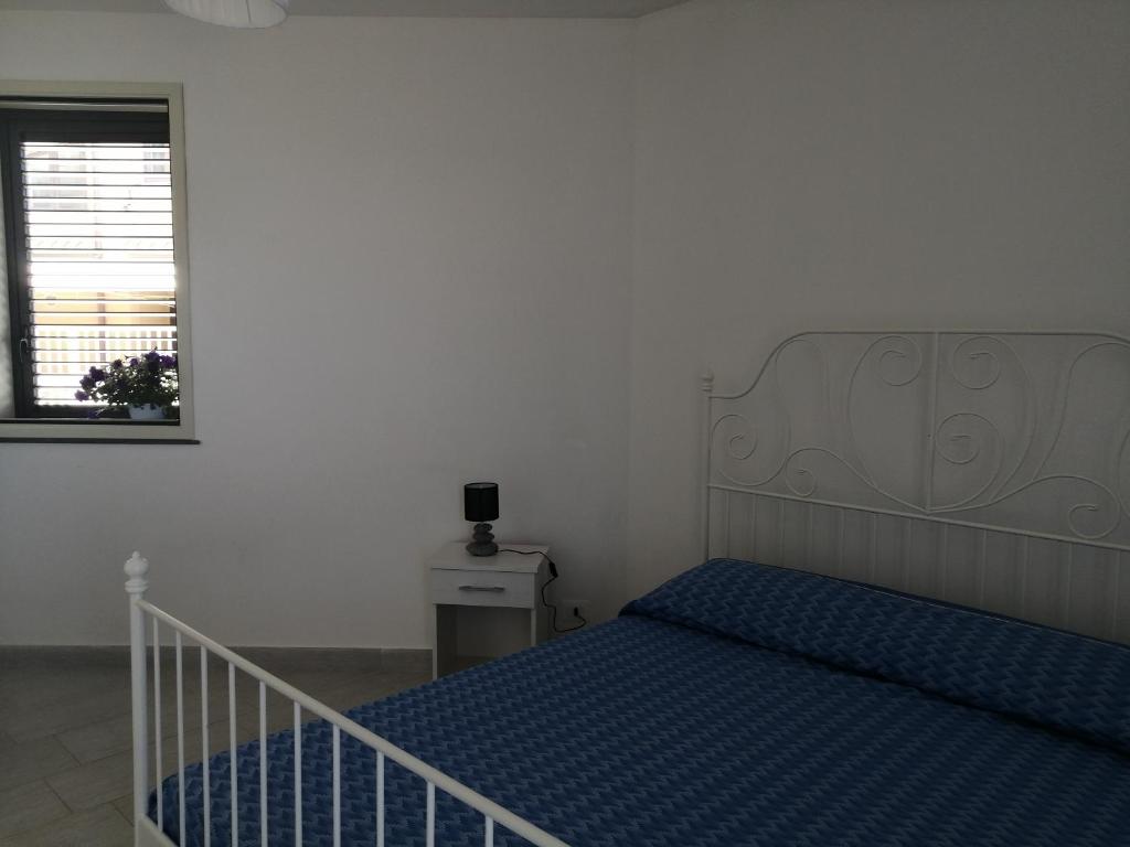 マルツァメミにあるCM HOUSE MARZAMEMIのベッドルーム1室(青いシーツと窓付)