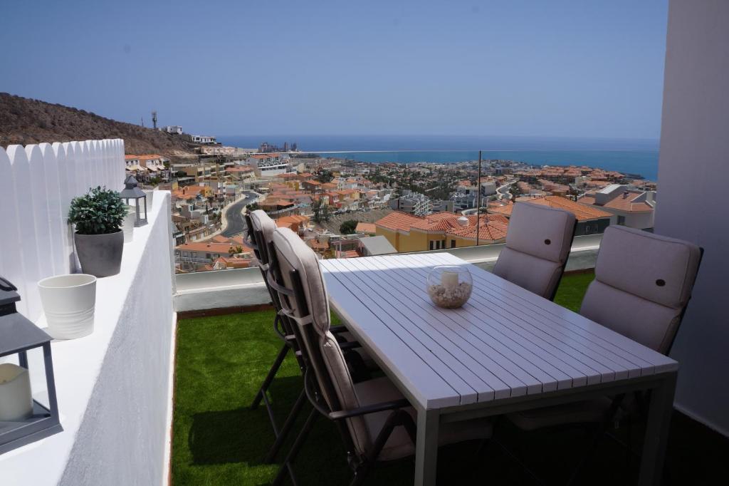 a table and chairs on a balcony with a view at Maravillosas vistas y el mejor clima del mundo! in La Playa de Arguineguín