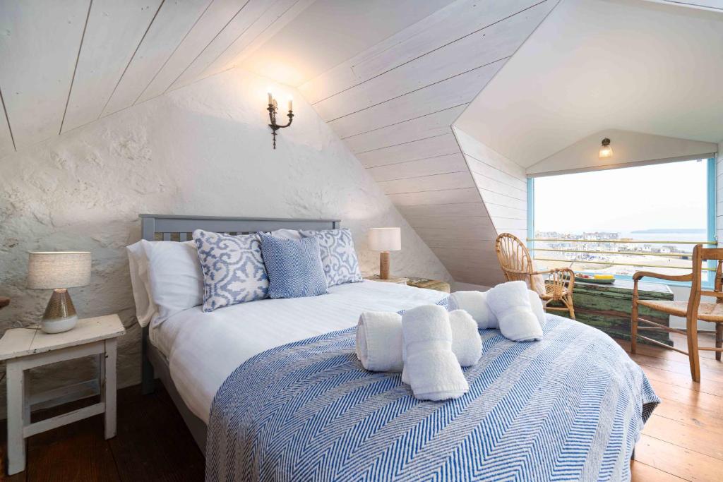 a bedroom with a bed with blue and white pillows at Secret Cottage in St Ives
