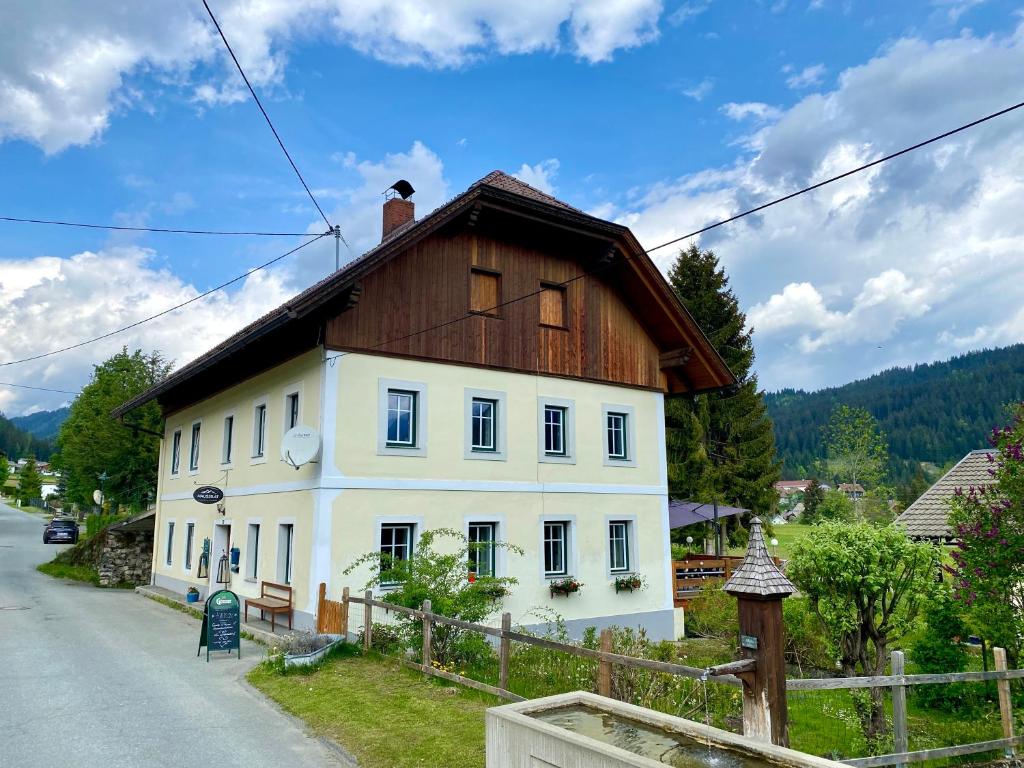 uma pequena casa branca com um telhado de madeira em Haus 26 Weißbriach em Weissbriach