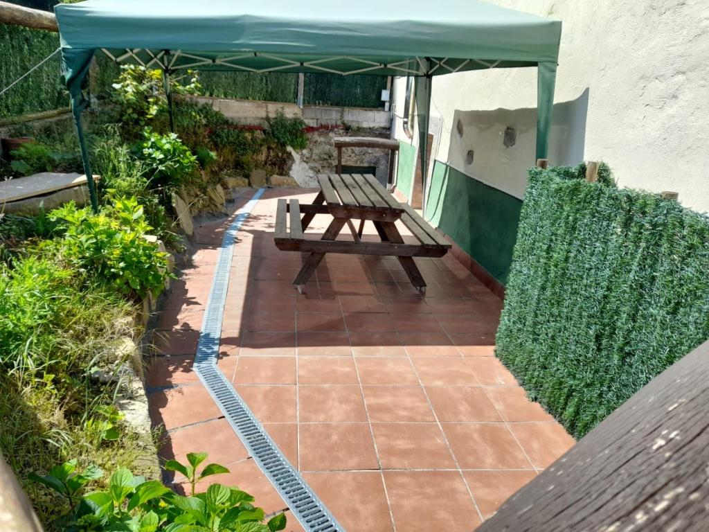 una mesa de picnic bajo un dosel en un patio en AGARRE URDAIBAI, en Mundaka