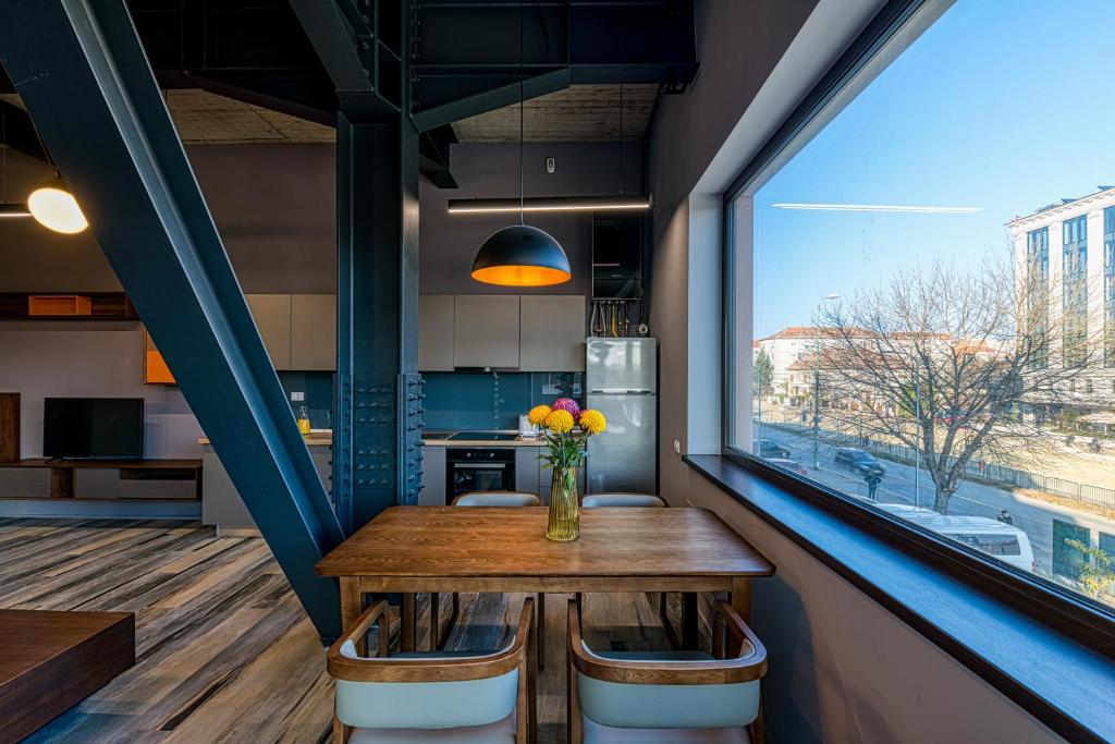 a dining room with a table and a large window at ArtHomes Apartments in Timişoara