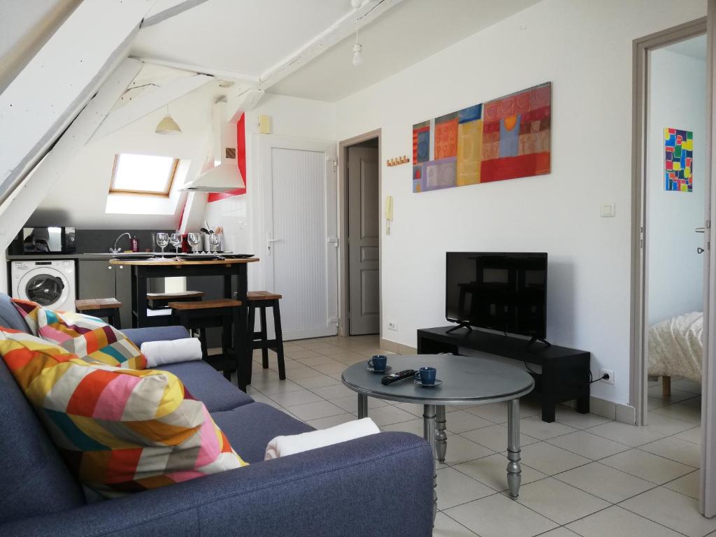 a living room with a blue couch and a table at gîte de l&#39;artiste Segré ✰ T2 confort ✰ centre ✰ 2 lits in Segré