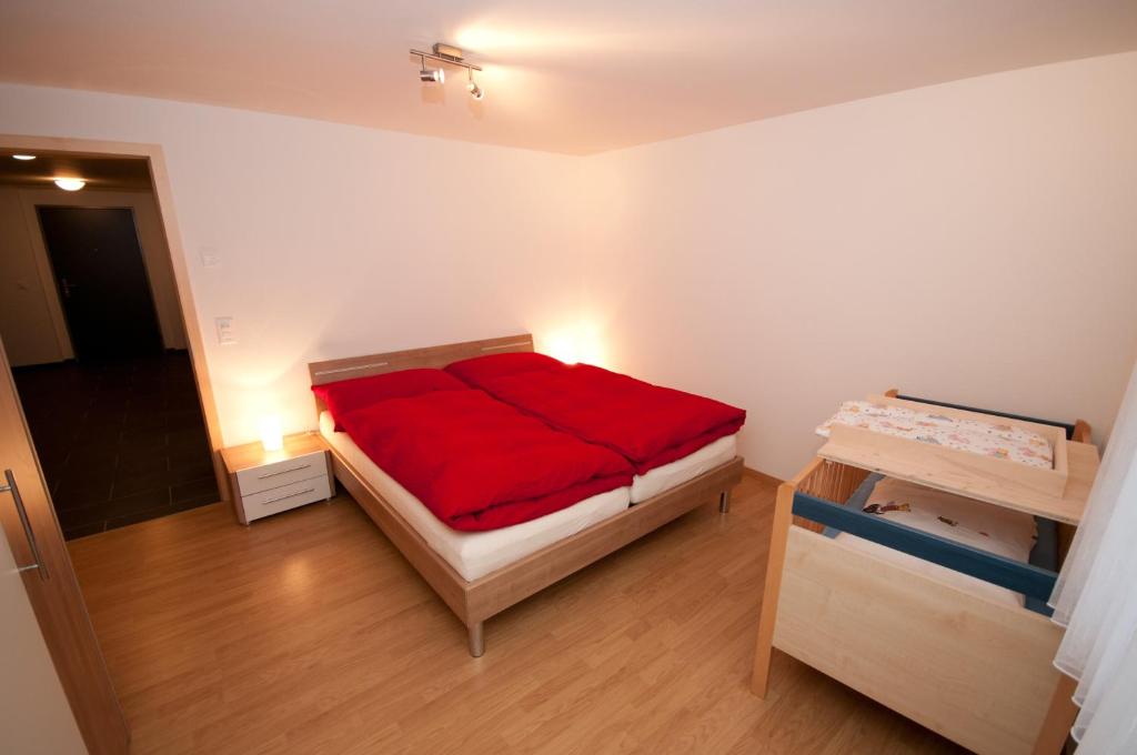 a room with a bed with a red blanket at Alpbachstrasse 4, Meiringen in Meiringen