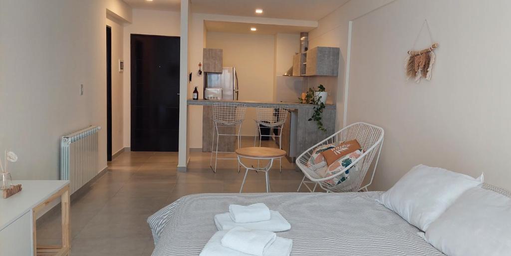 Habitación pequeña con cama y cocina en mstudio I Monoambiente VIRA en Puerto Madryn