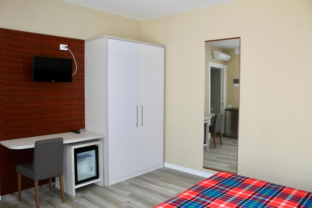 sypialnia z łóżkiem, biurkiem i telewizorem w obiekcie Hotel Cristina w Grado