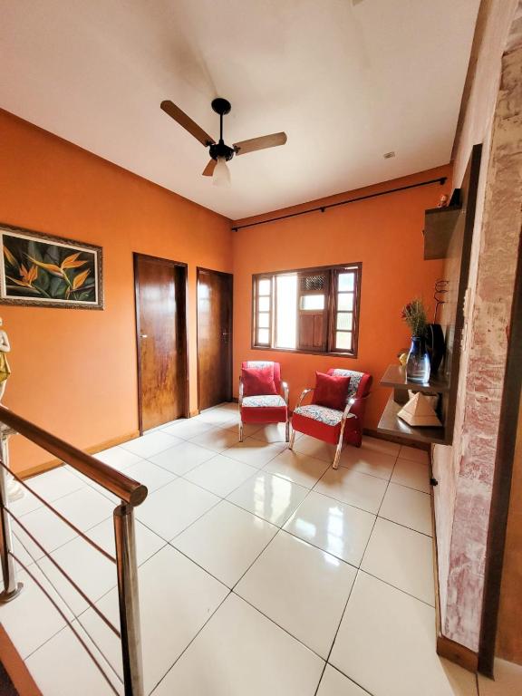 salon z pomarańczowymi ścianami i wentylatorem sufitowym w obiekcie Hospedagem da Miss w mieście Lençóis