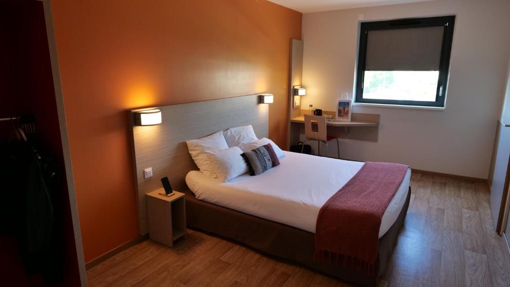 a hotel room with a bed and a window at Oneloft Hotel in Obernai