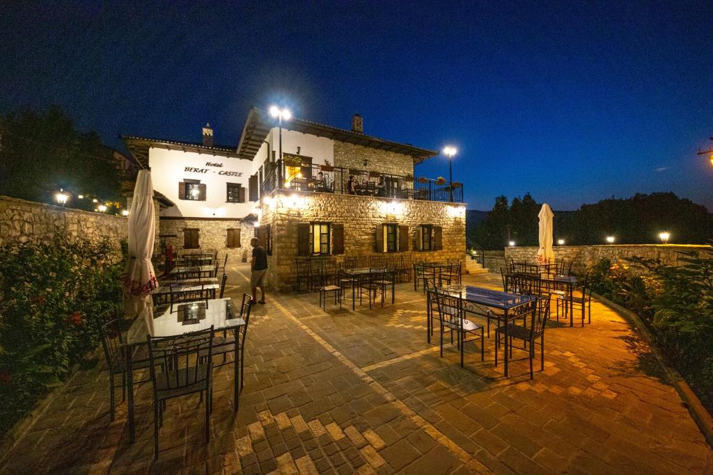 eine Gruppe von Tischen und Stühlen vor einem Gebäude in der Unterkunft Berati Castle Hotel in Berat